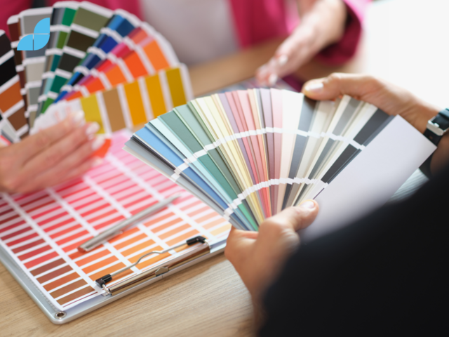 Two people discussing colours while holding colour palettes.