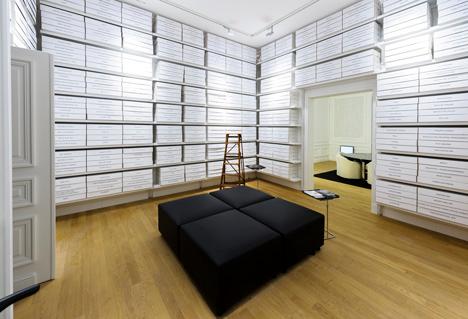 Organised style design, with several shelves and a seat in the middle of the room. 